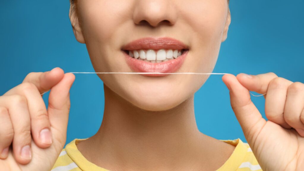 Woman Smiling While Holding Dental Floss