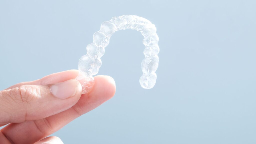 Hand Holding a Clear Aligner