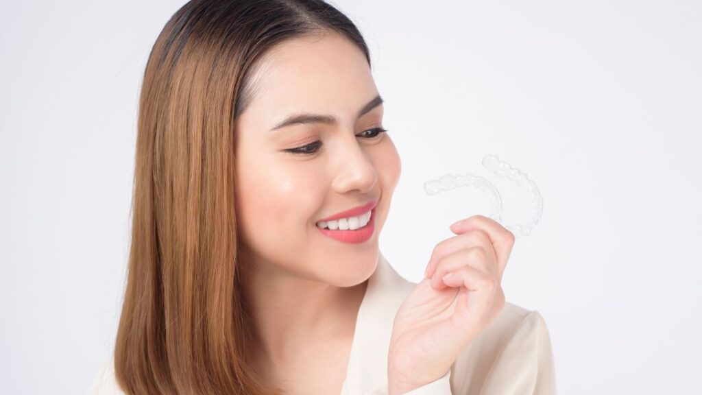 Woman Holding Invisalign Clear Aligners